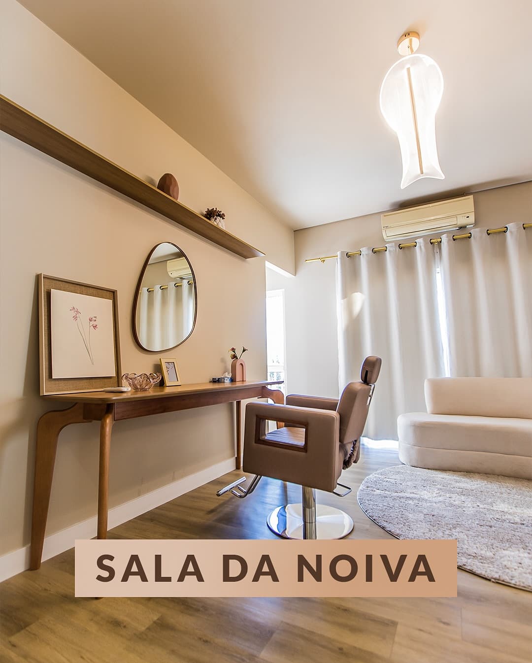 Sala da noiva com cadeira de couro, espelho orgânico, aparador de madeira e sofá claro